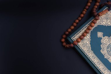 Kuran-ı Kalifiye 'nin Arapça çevirisi ve siyah arkaplanda tespih ya da Tasbih. Ramazan, Hac, İslami ve Kopyalama Alanı kavramı