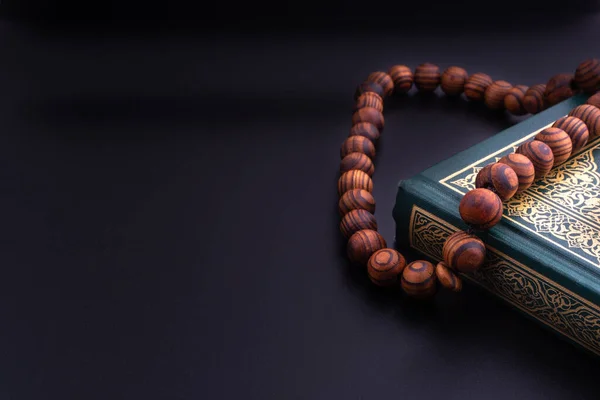 Kuran-ı Kalifiye 'nin Arapça çevirisi ve siyah arkaplanda tespih ya da Tasbih. Ramazan, Hac, İslami ve Kopyalama Alanı kavramı