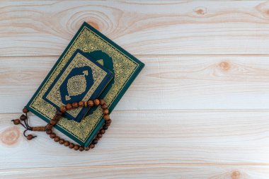 Kutsal Kur 'an' ın Arapça karşılığı olan el yazmaları ve ahşap arka planda tespih ya da tasbih. Ramazan, Hac, İslami ve Kopyalama Alanı kavramı