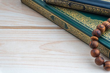 Kutsal Kur 'an' ın Arapça karşılığı olan el yazmaları ve ahşap arka planda tespih ya da tasbih. Ramazan, Hac, İslami ve Kopyalama Alanı kavramı