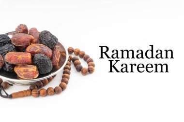 Beyaz arkaplanda hurma, kurma meyvesi, tespih ya da Tasbih bulunan RAMADAN KAREEM metni. Ramazan Kareem ve İslam Kavramı