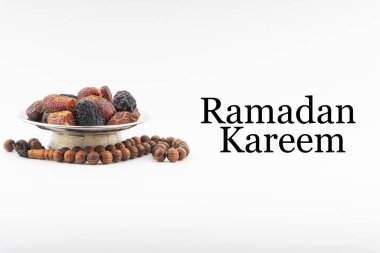 Beyaz arkaplanda hurma, kurma meyvesi, tespih ya da Tasbih bulunan RAMADAN KAREEM metni. Ramazan Kareem ve İslam Kavramı