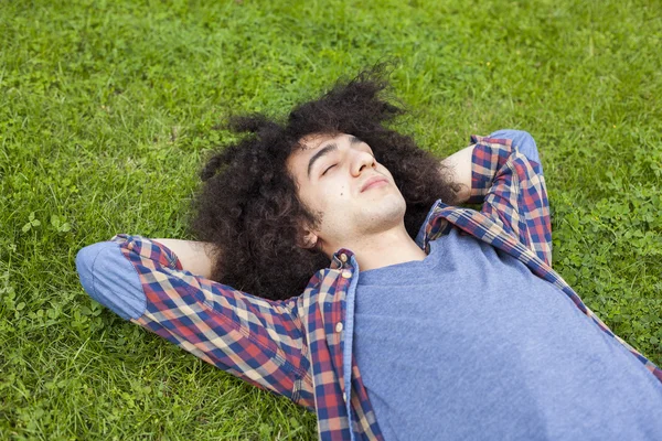 Junger Mann liegt auf Gras — Stockfoto