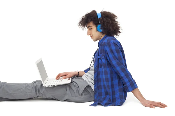Ung man lyssnar musik med hörlurar — Stockfoto