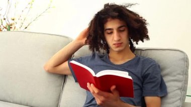 Genç adam kitap okuyor.