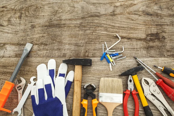 Strumenti di lavoro assortiti su fondo legno Immagine Stock