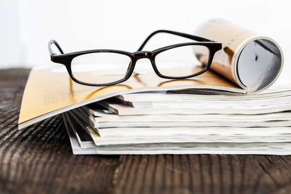 Revistas sobre mesa con gafas graduadas — Foto de Stock