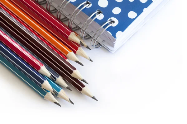 Lápices de color con cuaderno azul — Foto de Stock