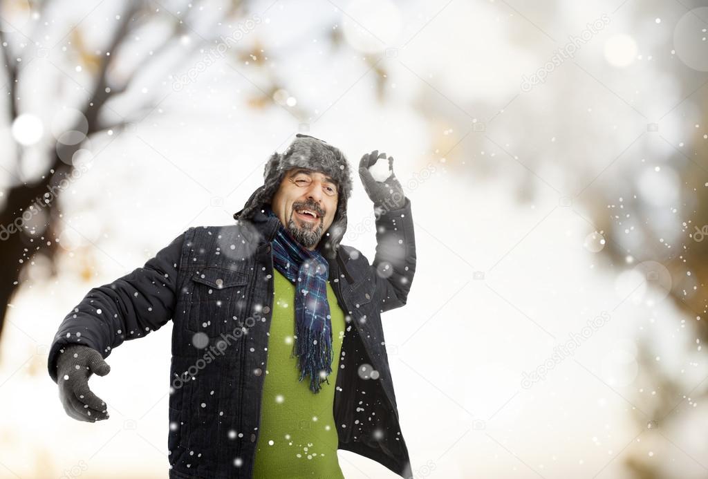 A senior man throwing a snowball