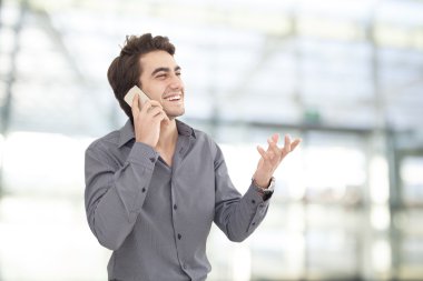 Genç işadamı cep telefonu ofiste konuşurken