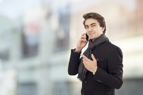 Young businessman talking mobile phone on street — Stock Photo, Image