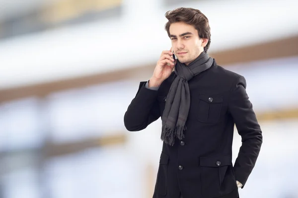 Young businessman talking mobile phone on street — Stock Photo, Image