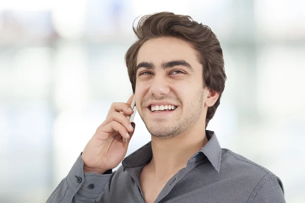 Young businessman talking mobile phone in the office — Stock Photo, Image