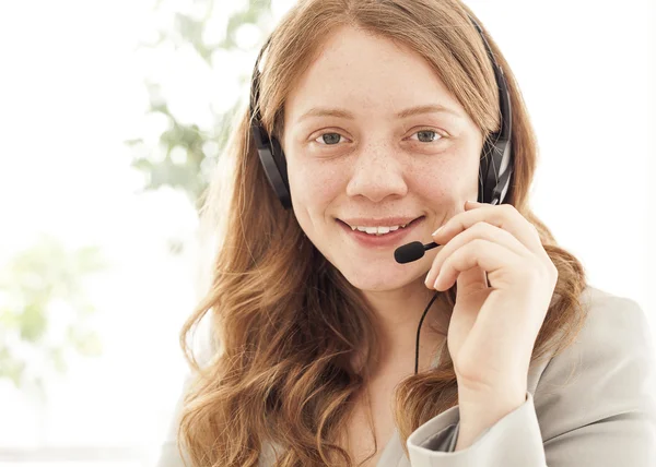 Portrait of happy young female with headset — Stock Photo, Image