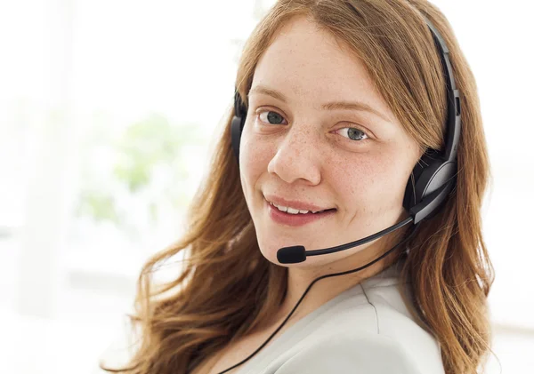 Portrait of happy young female with headset — Stock Photo, Image