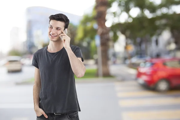Mladý muž mluvící mobilní telefon na ulici — Stock fotografie