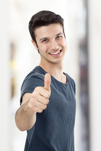 Joven mostrando signo OK con el pulgar hacia arriba — Foto de Stock