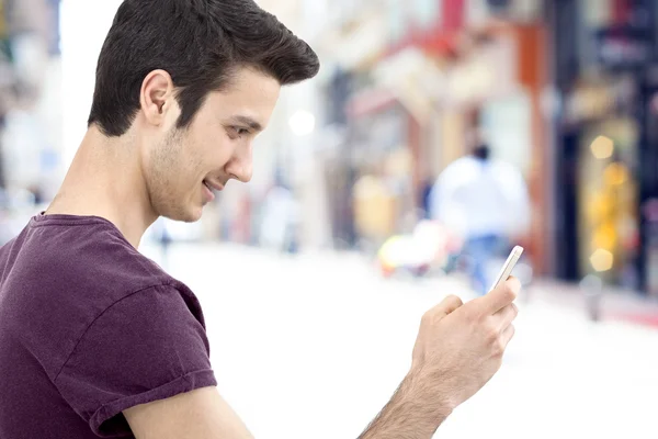 Молодой человек пишет сообщение на мобильном телефоне — стоковое фото