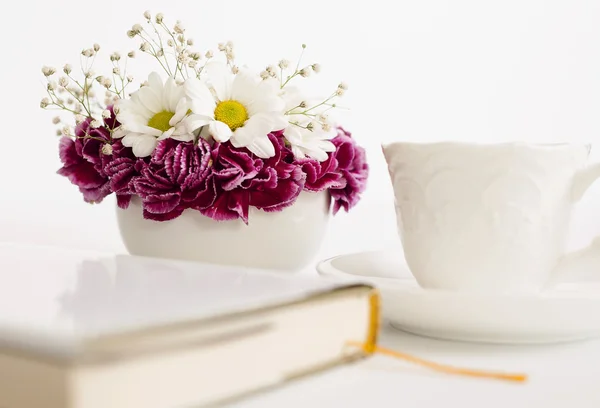 Krásná kytice s kelímkem a kniha — Stock fotografie