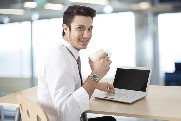 Бизнесмен, работающий над ноутбуком и пьющий кофе — стоковое фото