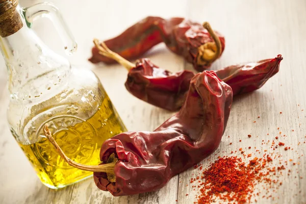 Red dry pepper and olive oil on wooden table — Zdjęcie stockowe