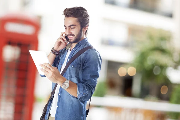 Young man talking mobile phone in street — Stock Photo, Image