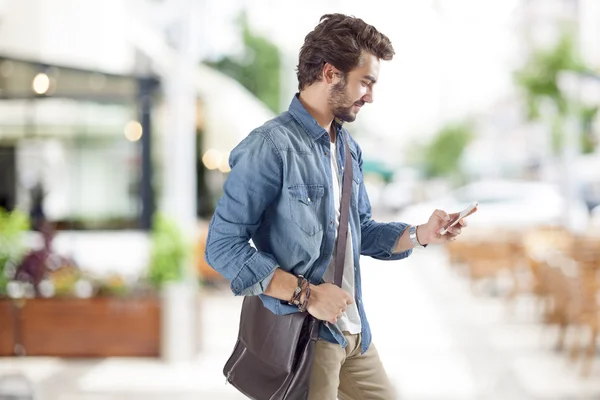 Jonge man met behulp van mobiele telefoon in street — Stockfoto