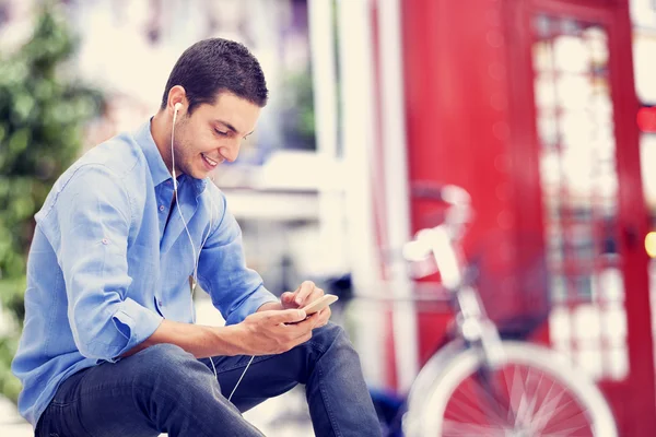 Hombre joven usando teléfono móvil — Foto de Stock