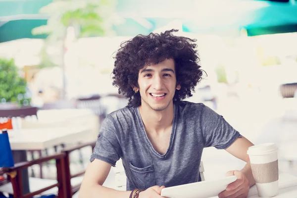 Young man holding digital tablet in cafe — Stock Photo, Image