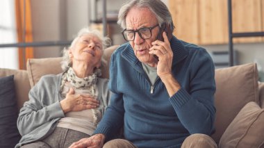 Olgun bir adam, karısı için ambulans çağırıp evdeki kanepede kalp krizi geçiriyor.