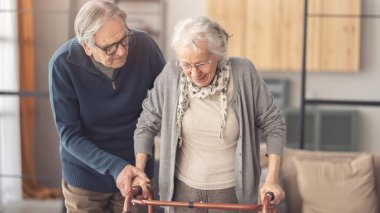 Yaşlı bir çift yürürken birbirlerine yardım ederler.