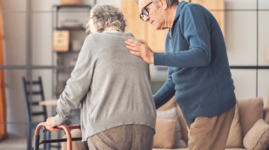 Yaşlı bir çift yürürken birbirlerine yardım ederler.