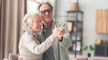 Mutlu bir çiftin portresi dans edip evde eğleniyor..