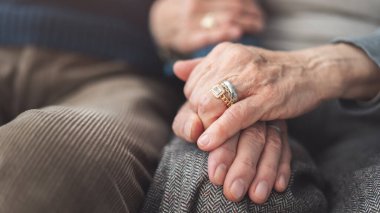 Yaşlı çift el ele tutuşup birbirlerine destek oluyor.