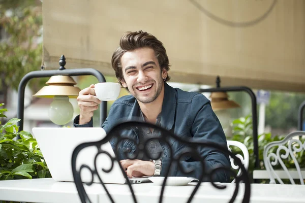 Young man drinking coffee in cafe — Stock Photo, Image
