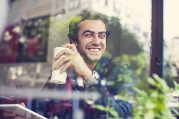 Jonge man drinkt koffie in Cafe — Stockfoto