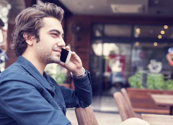 Ung man pratar telefon i café — Stockfoto