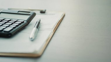 Hesap makinesi ve belgeler masada.