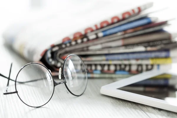 Pilha de jornais, óculos e tablet digital — Fotografia de Stock