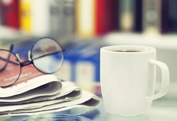 Taza de café y periódico en la mesa — Foto de Stock