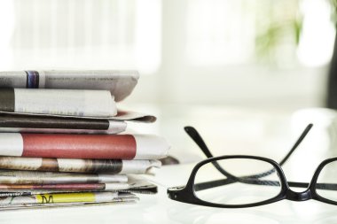 Gazeteler ve gözlük yığını