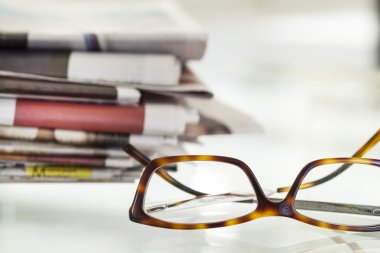 Gazeteler ve gözlük yığını