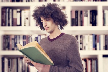 Genç adam Kütüphanesi'nde kitap okumak