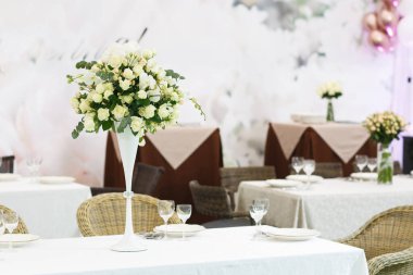 Düğün ziyafeti dekorasyonu geçmişi. Bir parti, düğün resepsiyonu ya da diğer şenlikli etkinlikler için çanak çömlek ve çiçeklerle dolu romantik bir masa. Akşam yemeği için cam eşyalar ve çatal bıçaklar..