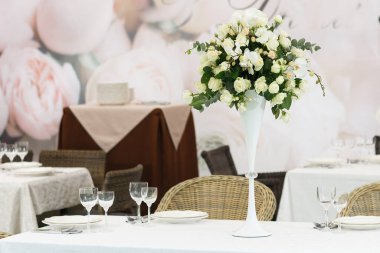 Düğün ziyafeti dekorasyonu geçmişi. Bir parti, düğün resepsiyonu ya da diğer şenlikli etkinlikler için çanak çömlek ve çiçeklerle dolu romantik bir masa. Akşam yemeği için cam eşyalar ve çatal bıçaklar..