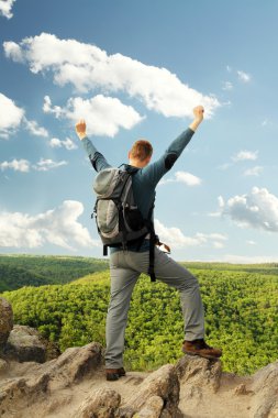 Adam dağın tepesinde duruyor.