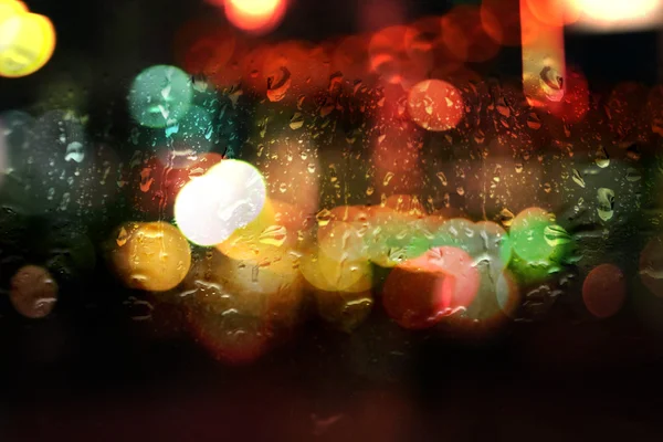 Мокрое окно с ночным боке огней — стоковое фото