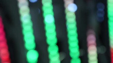 Siyah Bacgrkound üzerinde Bokeh etkisi olan mavi, kırmızı, yeşil titreşimli parti hatları. Parlak Odaklanmış Parıldayan Neon Işıkları Yavaş Hareketi. Bokeh 'in çok renkli Soyut Tatil Arkaplanı. Bulanık Renkli Şerit