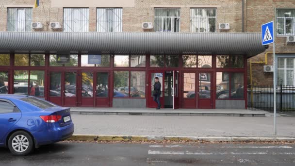 Detektywi i pracownicy wchodzą i wychodzą z biura drzwi wejściowych NABU. Fasada budynku siedziby Krajowego Biura Antykorupcyjnego Ukrainy w Kijowie — Wideo stockowe