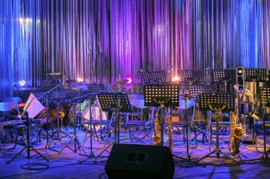 Müzik Enstrümanları ve Çarşafları, Rock 'ta Canlı Sahne veya Caz Konseri veya Renkli Işıklandırma Festivali' nde Sahneye Hazır Bekliyor. Orkestra için Boş Sahne. Çevrimiçi Müzik Konseri veya Etkinliği